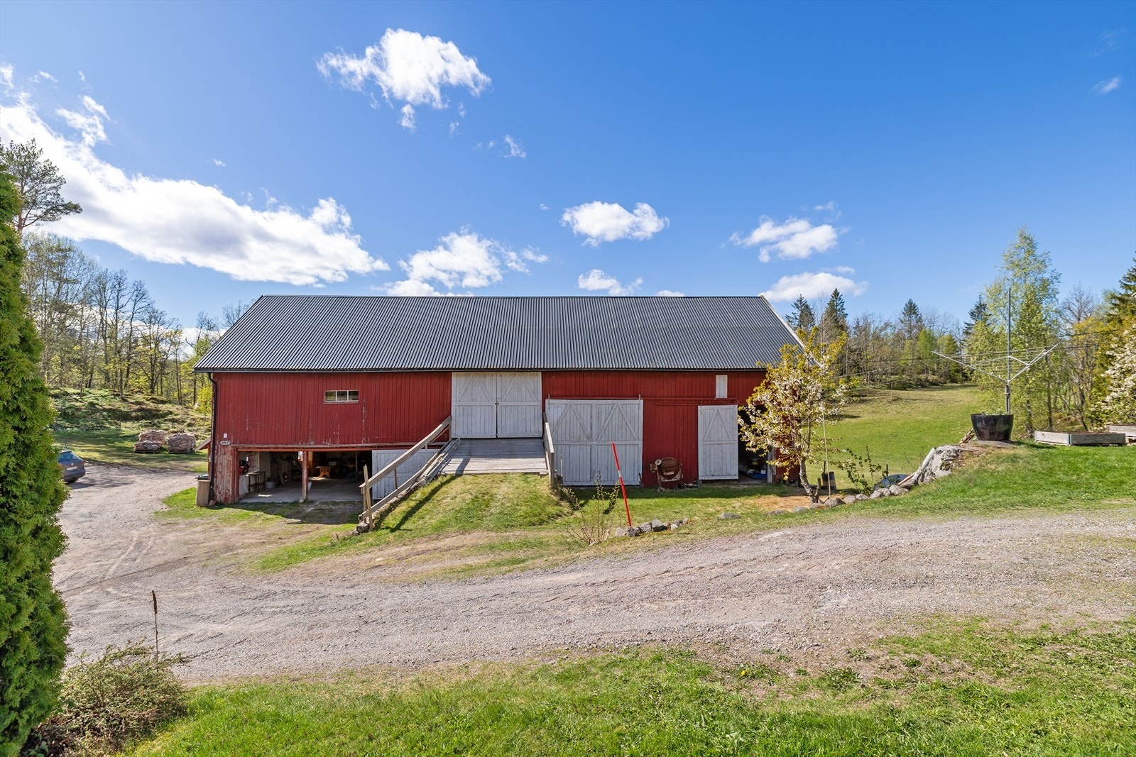 Driftsbygningen i Oppistua. 1. etg: Gjødselskjul (bak), bod, garasjeplasser i gml fjøs, div lager og to høytørker (ca 75m2). 2.etg: Låve / kaldtlager. Galleribilde