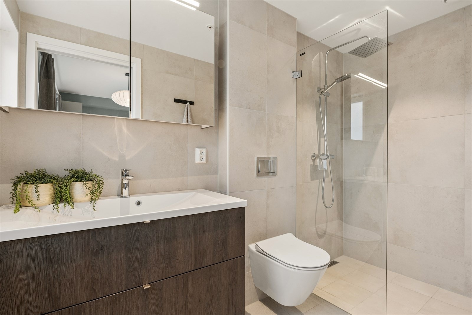 Det private badet er helfliset og har vannbåren gulvvarme. Rommet har innredning med nedfelt servant, veggmontert toalett og dusjvegger/hjørne. Balansert ventilasjon. Downlights. Galleribilde