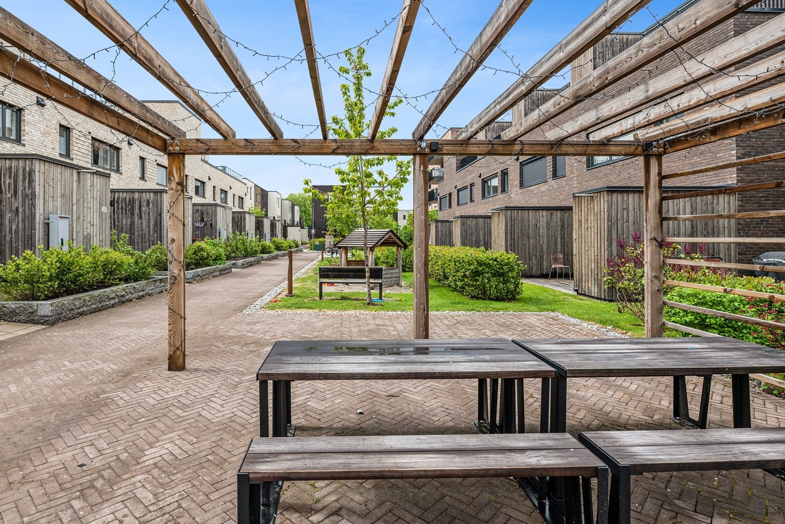 Sameiet har pent opparbeidede fellesarealer med pergola, sitteplasser og lekeapparater. Galleribilde
