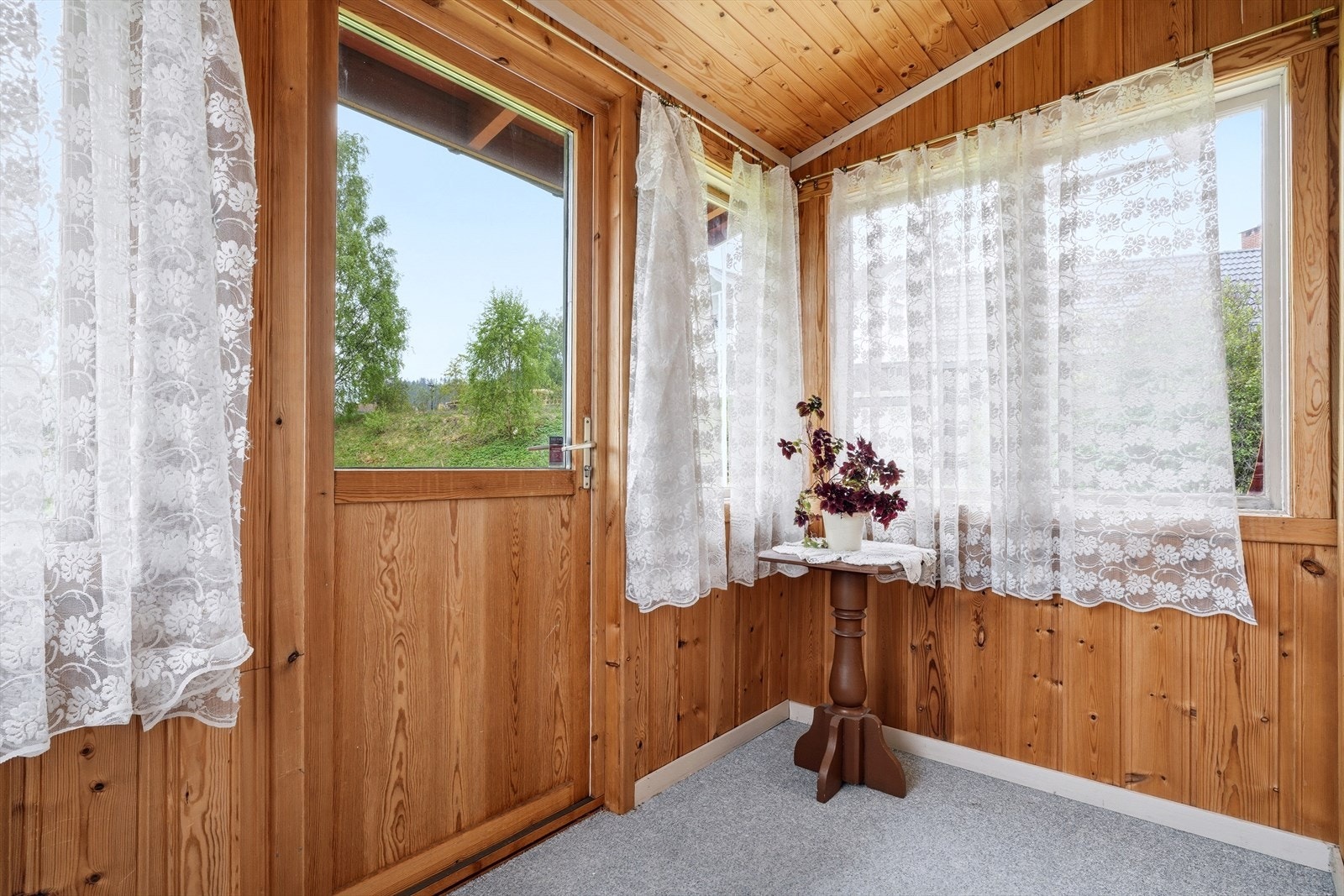 Innglasset veranda ved stuen, som gir et lunt uterom. Galleribilde