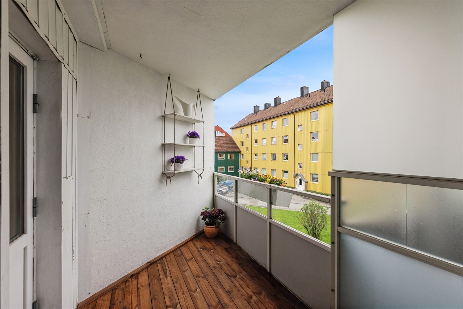 Fra balkongen ser du ut over borettslagets grønne fellesområder og lekeplass. Galleribilde