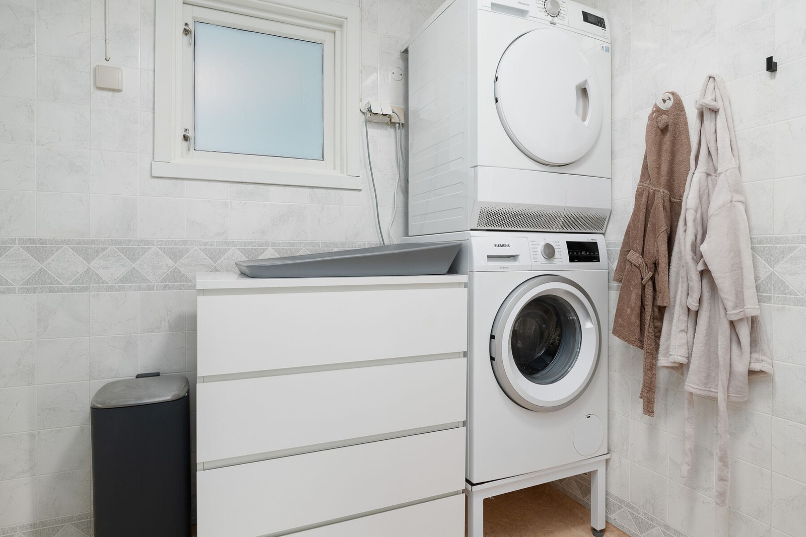 Badet er praktisk innredet med opplegg for vaskemaskin og tørketrommel. Galleribilde