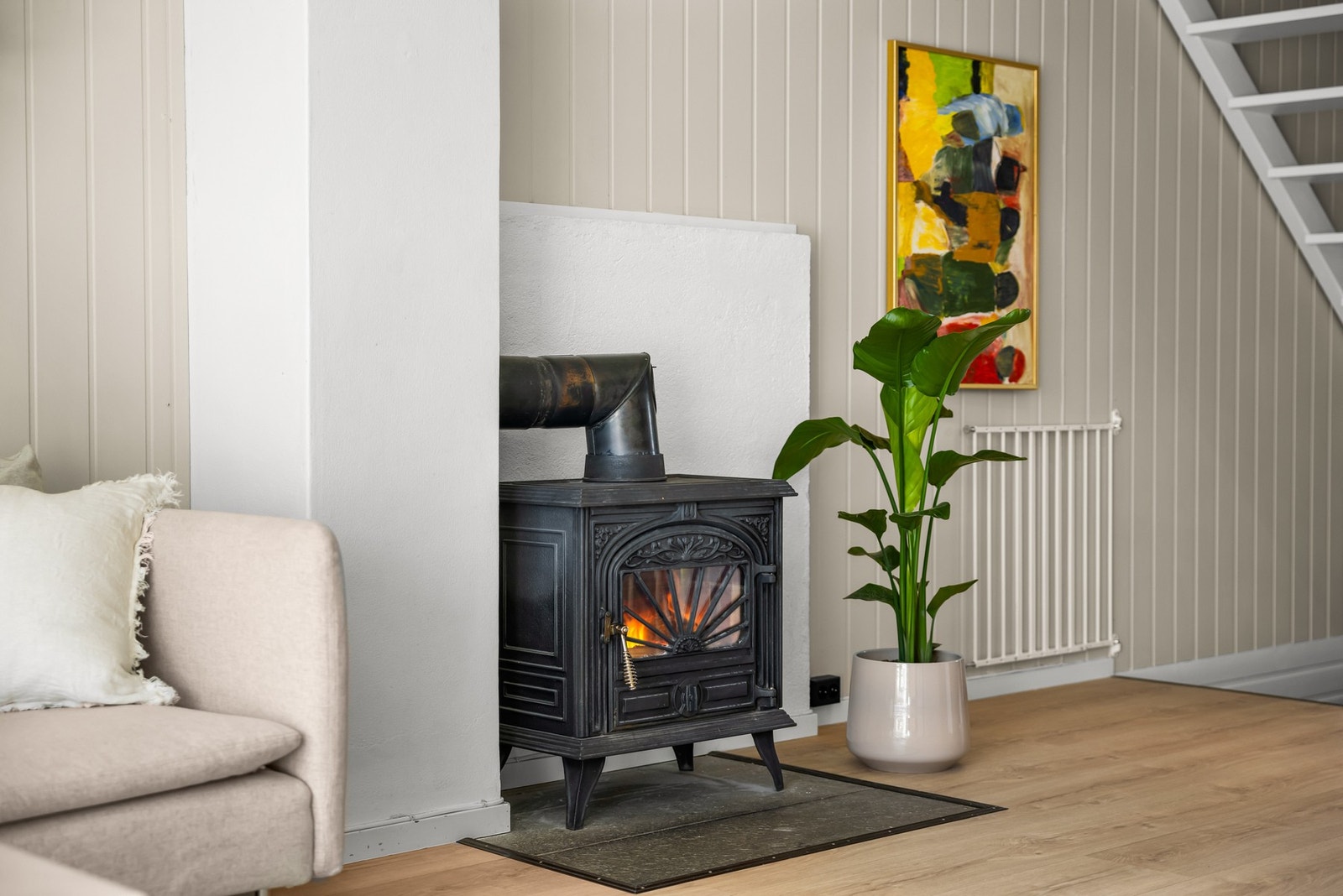 Rommets peisovn skaper både varme og ekstra hygge på kjøligere dager, mens varmepumpen sørger for behagelig kjøling gjennom sommermånedene. Galleribilde