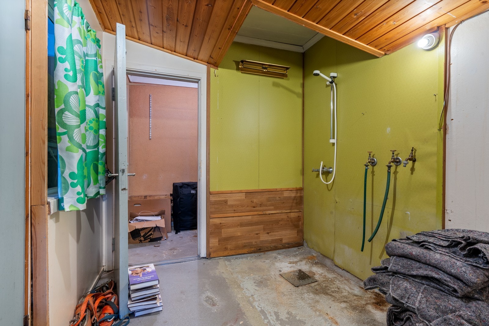 Badet i kjelleren har tak med umalt panel, vegger med malte plater og gulv i betong - badet har et omfattende oppgraderingsbehov for å kunne tilfredsstille dagens krav til våtrom Galleribilde