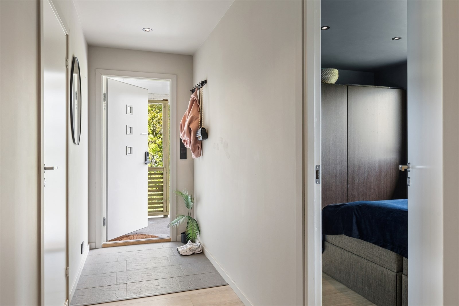 Entréen ønsker velkommen inn i boligens første etasje, som har gjennomgående laminatgulv og malte veggflater. Galleribilde
