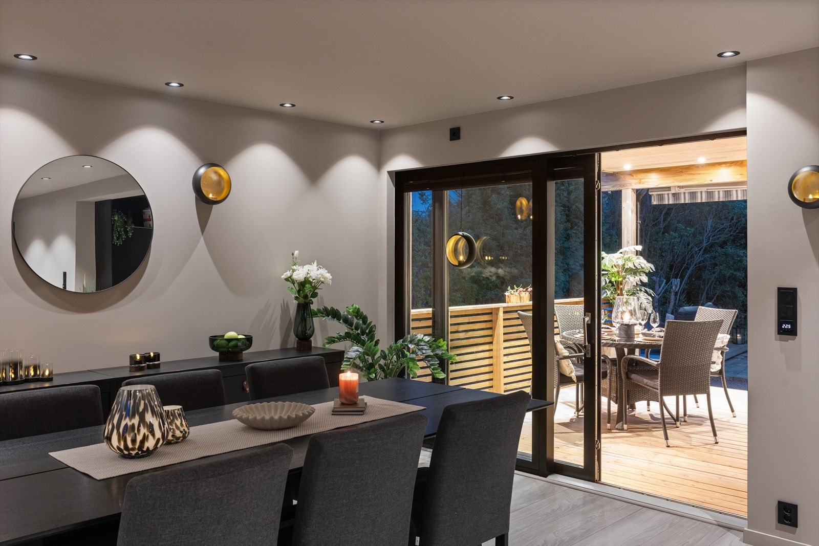 Kveldsstemning i spisestuen med utsikt mot den opplyste terrassen. Galleribilde