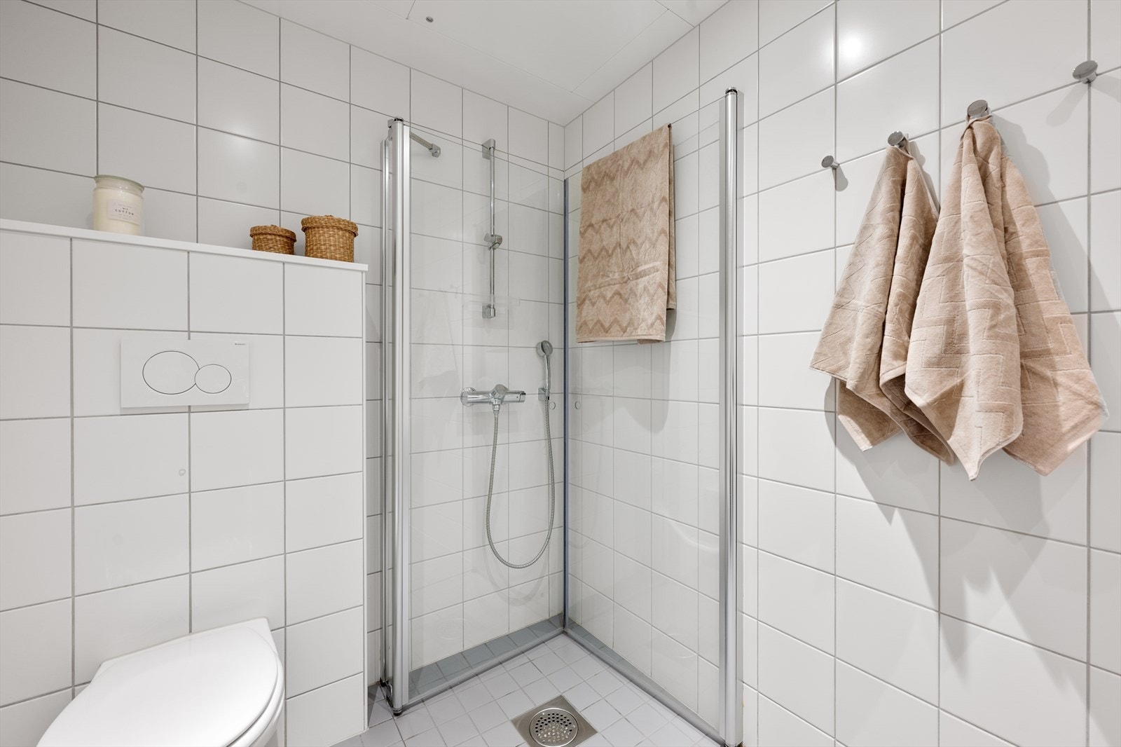 Badet er innredet med vegghengt toalett, servant og dusjløsning - opplegg for vaskemaskin Galleribilde