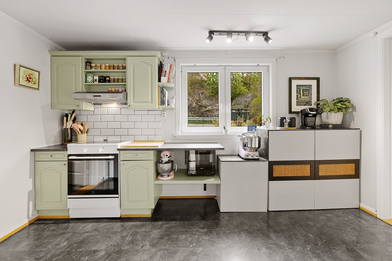 Innredningen har profilerte fronter, laminert benkeplate med kum, opplegg for oppvaskmaskin og frittstående hvitevarer. Galleribilde