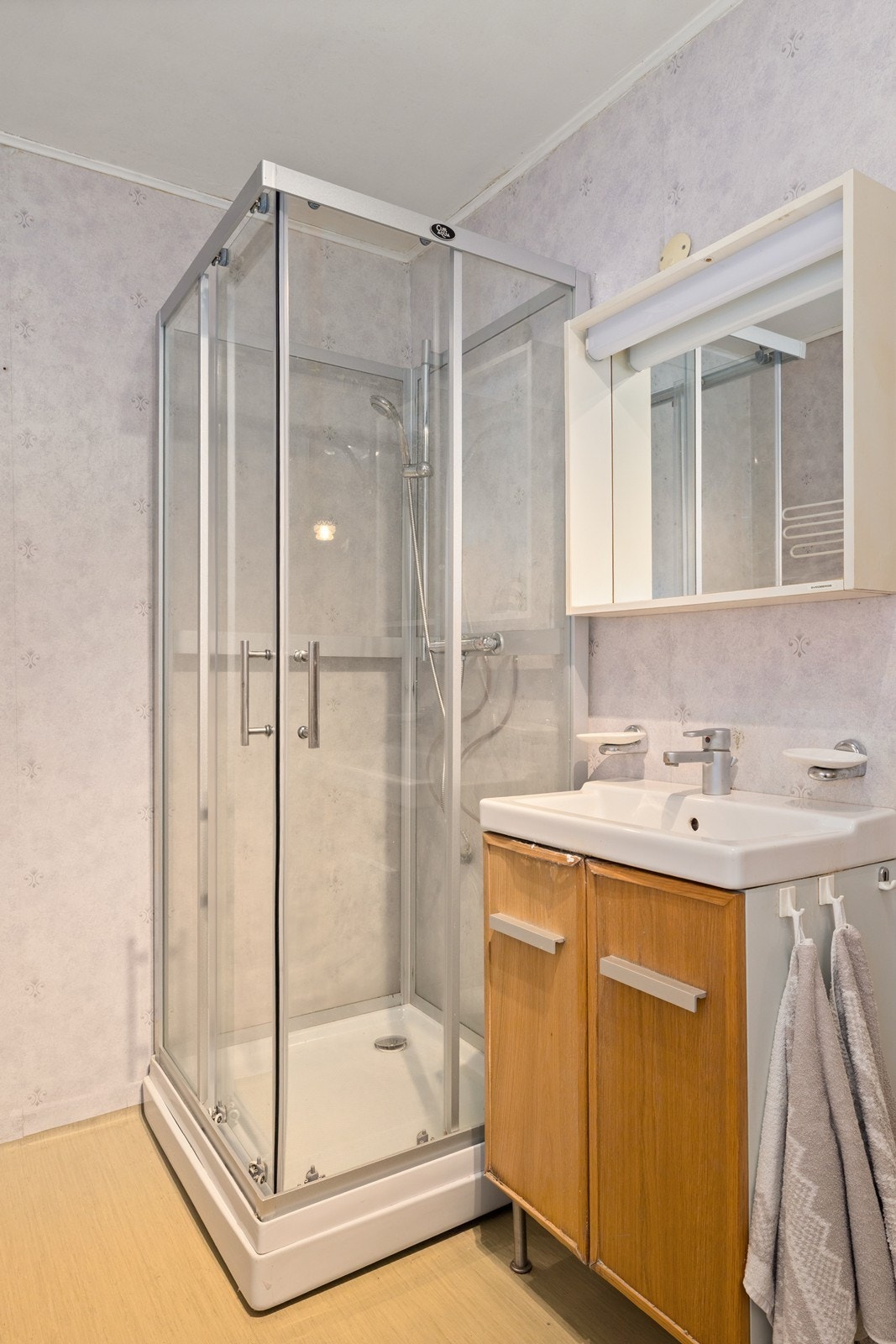 Badet har innredning med servant, speilskap og en vegghengt stråleovn. Galleribilde