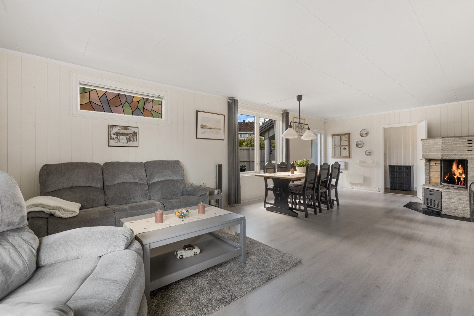 Her blir du møtt av en stor og åpen stue, hvor vedovnen skaper en lun atmosfære og bidrar med ekstra varme og hygge. Galleribilde