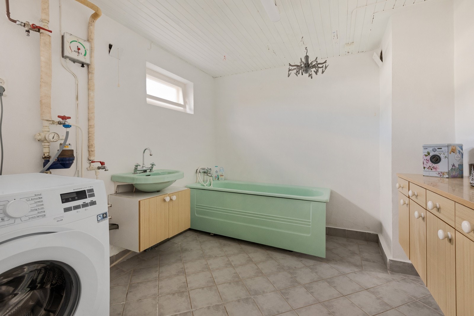 Her nede er det bla. et stort vaskerom i kjelleren, innredet med badekar, servant og opplegg for vaskemaskin. Galleribilde