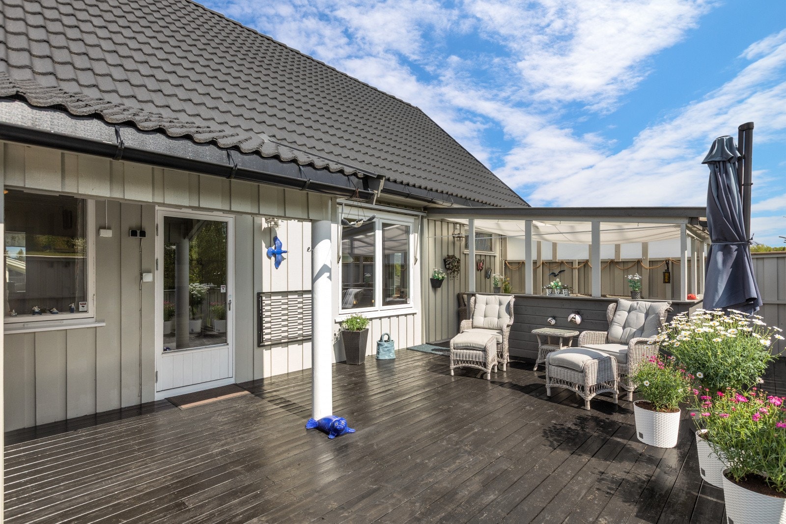 Terrassen med utgang fra stuen har flere soner, inkludert en del med pergola som gir ly for vær og vind. Galleribilde