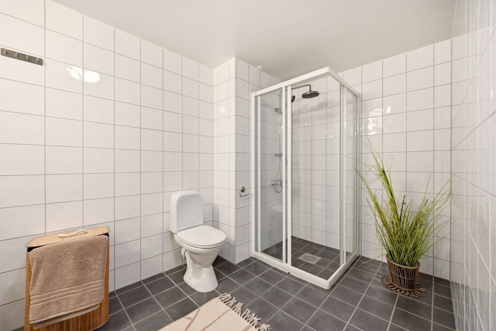 Stort, praktisk baderom med opplegg for vaskemaskin. Galleribilde
