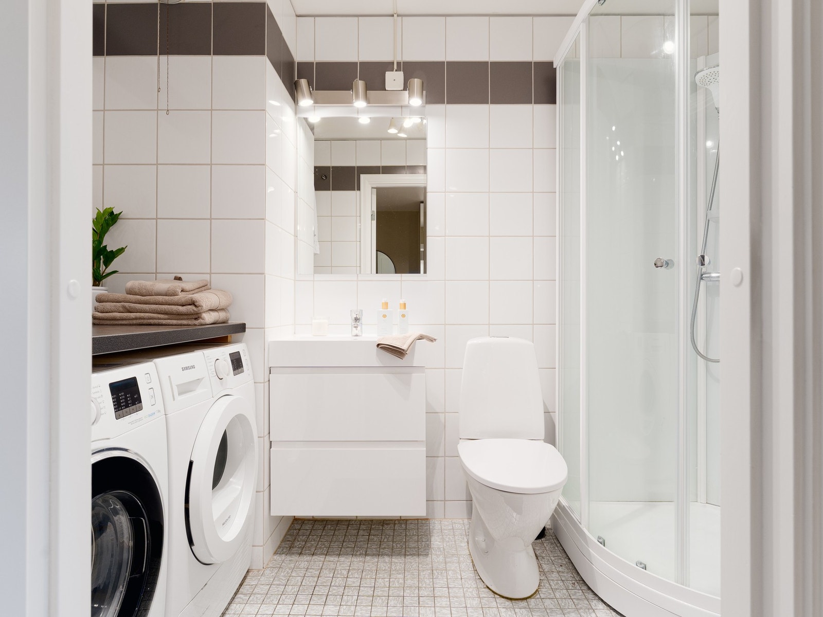 Badet er lyst og praktisk med helflislagte vegger, varmekabler i gulvet og et romslig dusjkabinett. Galleribilde