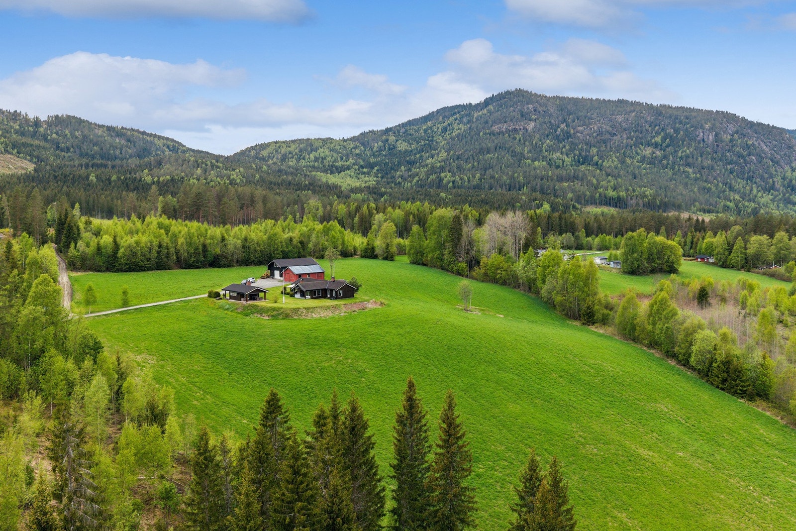 Eiendommen ligger landlig til med flott utsikt over grønne åser og skogkledde fjell. Galleribilde