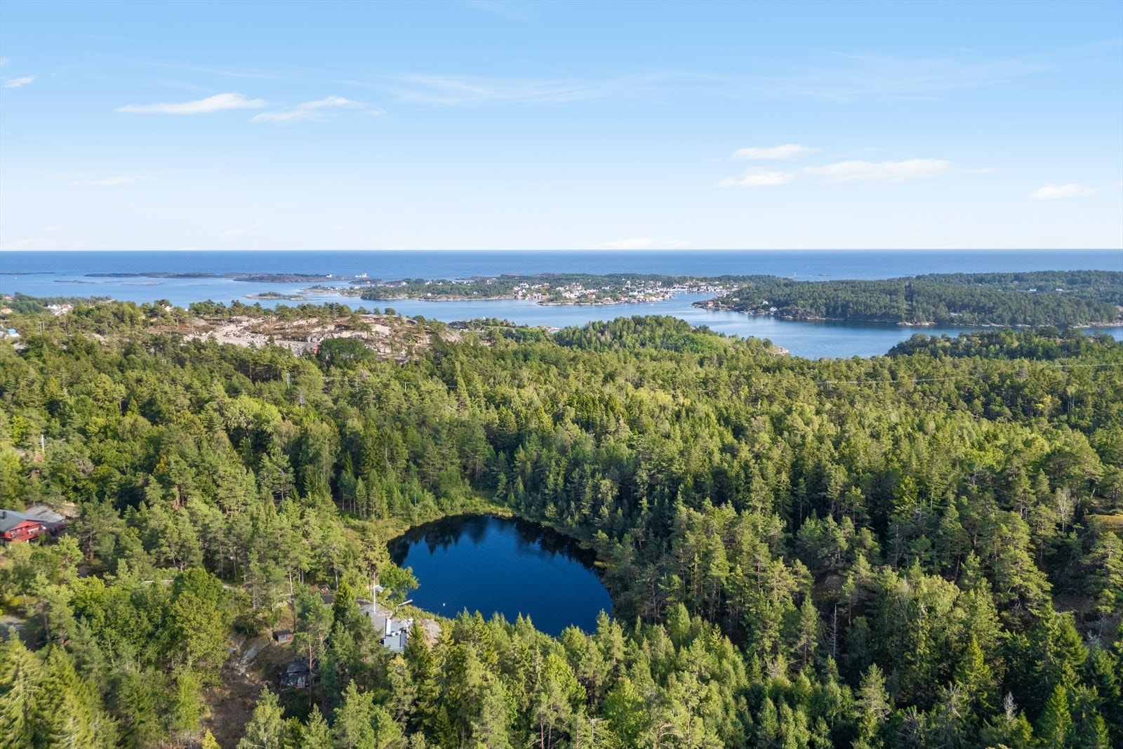 Dronebilde over tjernet og havet, her er det fint å trekke seg tilbake etter en dag på sjøen Galleribilde