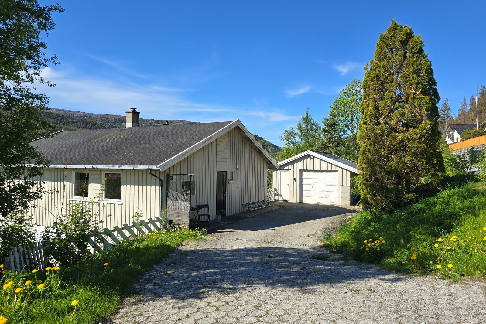 Innholdsrik enebolig med steinlagt gårdsplass og garasje. Galleribilde