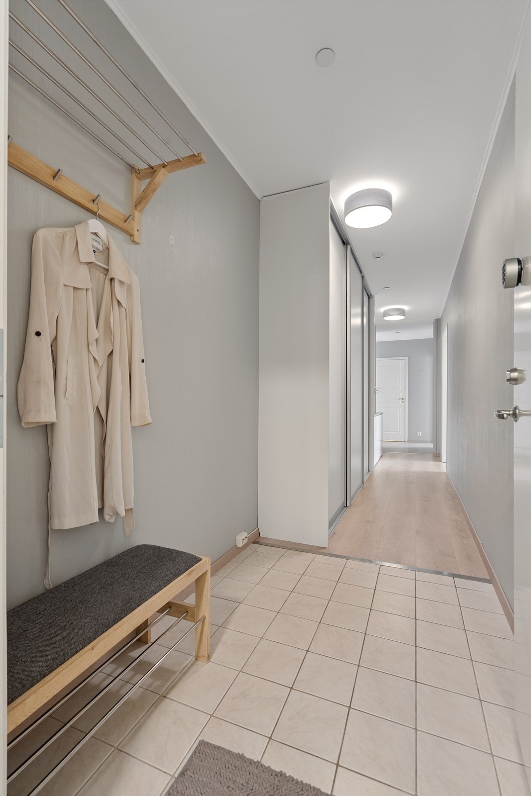 Romslig entré med flislagt gulv og praktisk skyvedørsgarderobe. Galleribilde