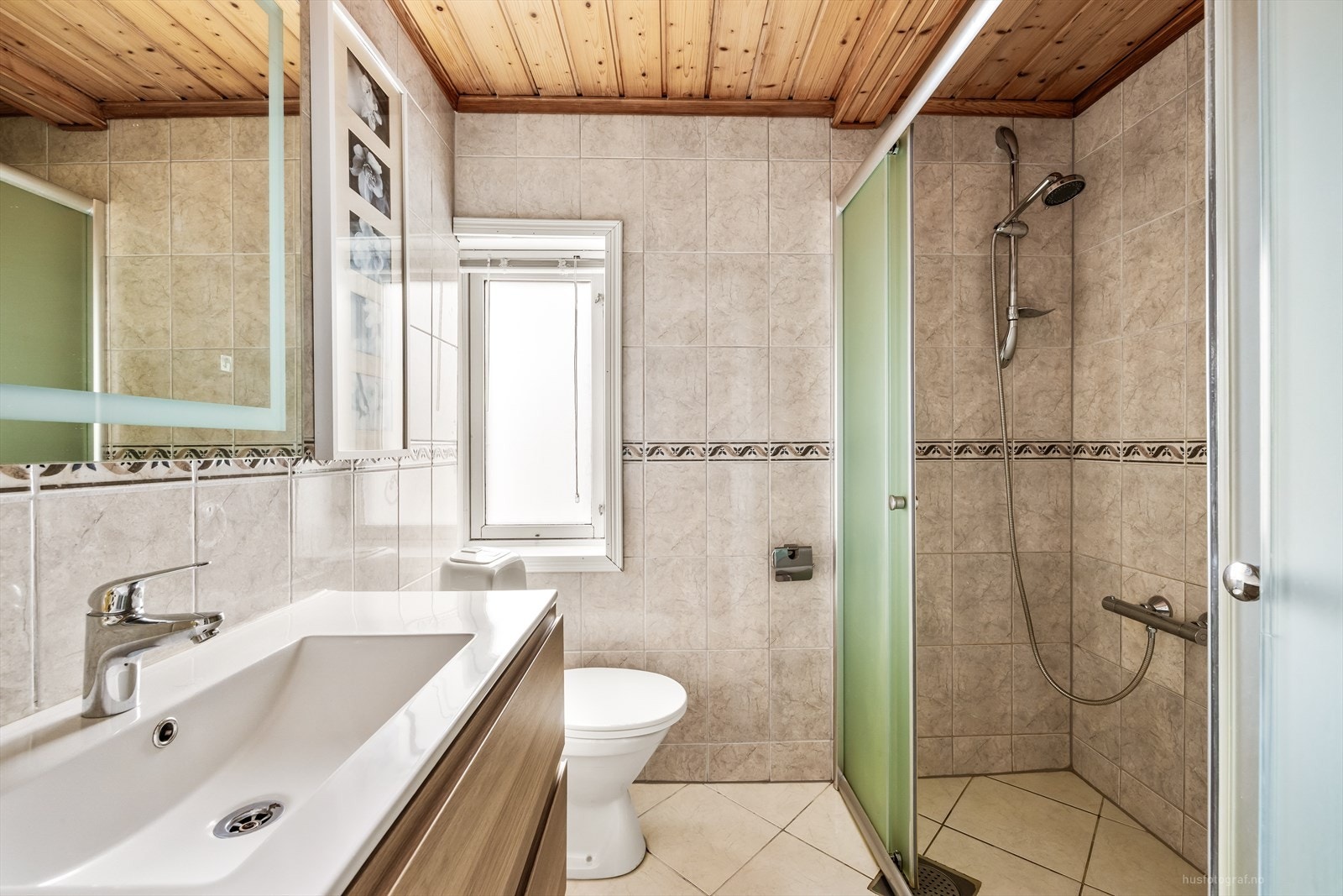 Badet har varme i gulvet, dusjhjørne og innredning med nedfelt servant. Galleribilde