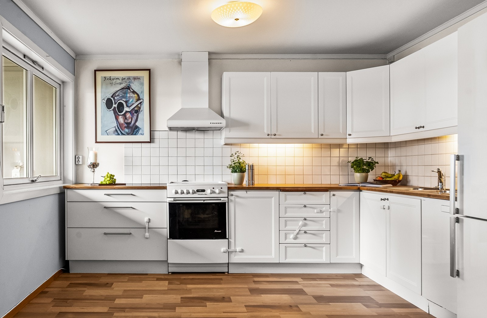 Kjøkkeninnredning med en kombinasjon av profilerte og glatte fronter. Benkeplaten er i heltre og laminat. Galleribilde