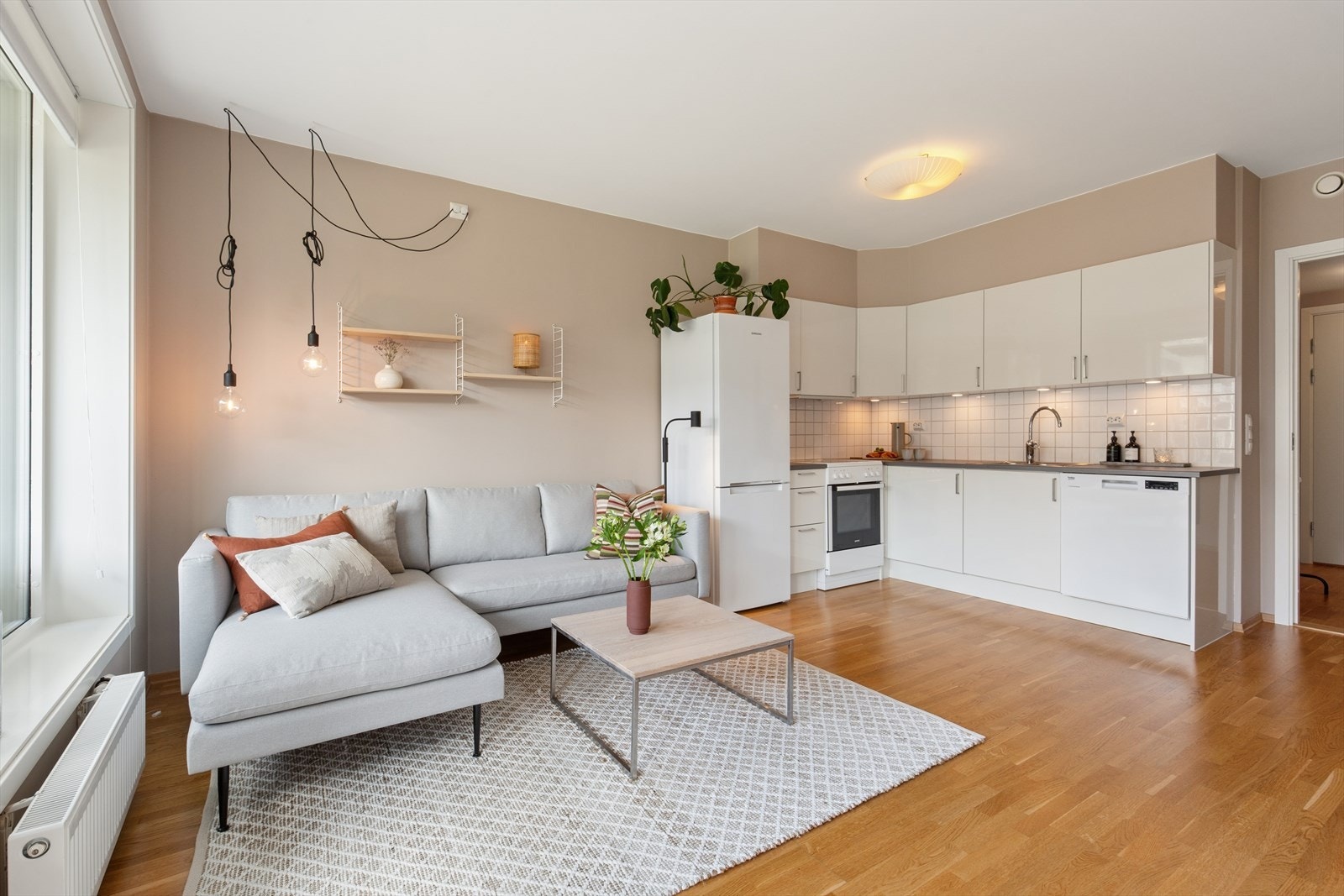 Stilrent kjøkken med med slette fronter av høyglans og bankplate av laminat. Galleribilde