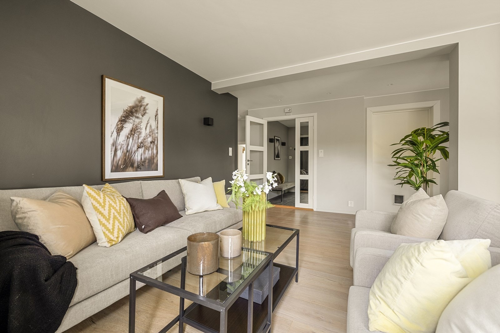 En mørkere fondvegg skaper en lun og definert sone for sofagruppen. Galleribilde