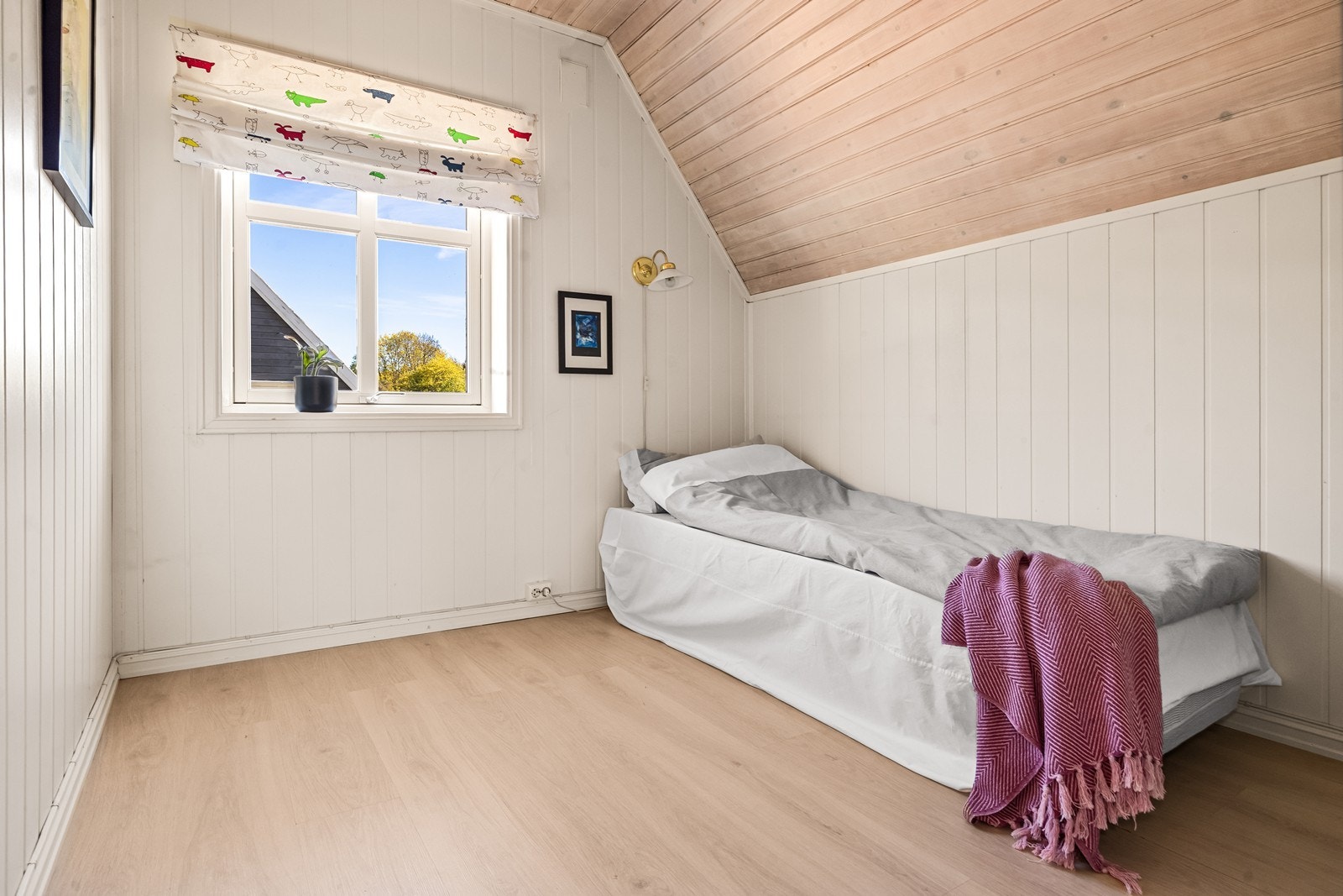 Det ene av to soverom i andre etasje, med panel i taket og laminat på gulvet. Galleribilde
