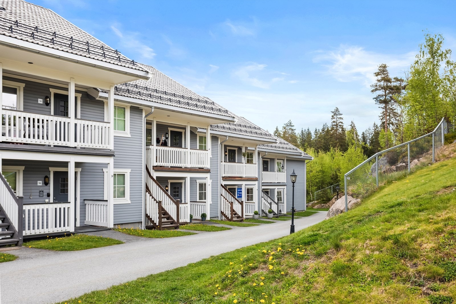 Pent opparbeidede fellesarealer med asfalterte internveier, plenarealer og noe beplantning. Galleribilde