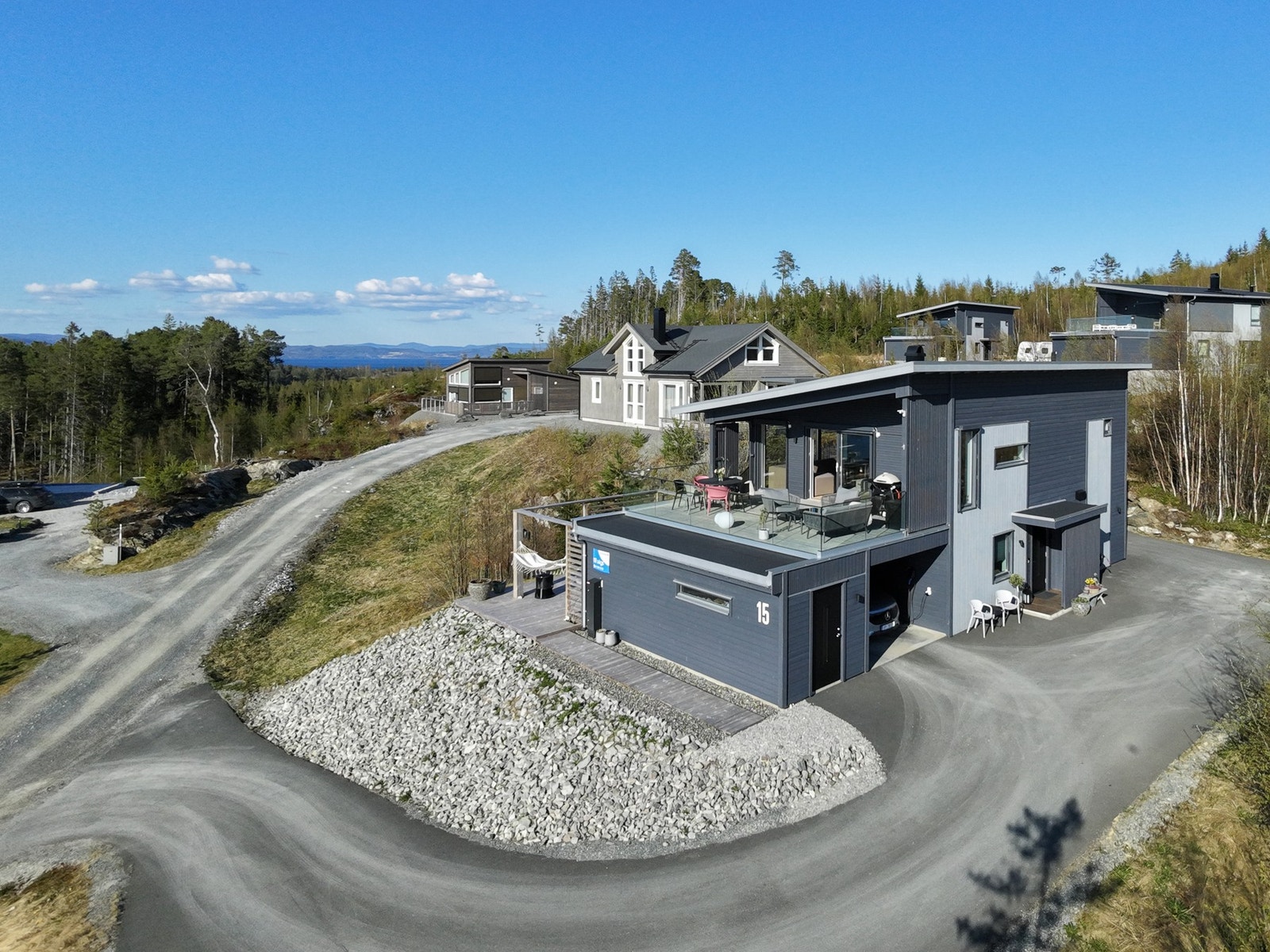 Asfaltert oppkjørsel og gårdsplass. Parkering i carport. Galleribilde