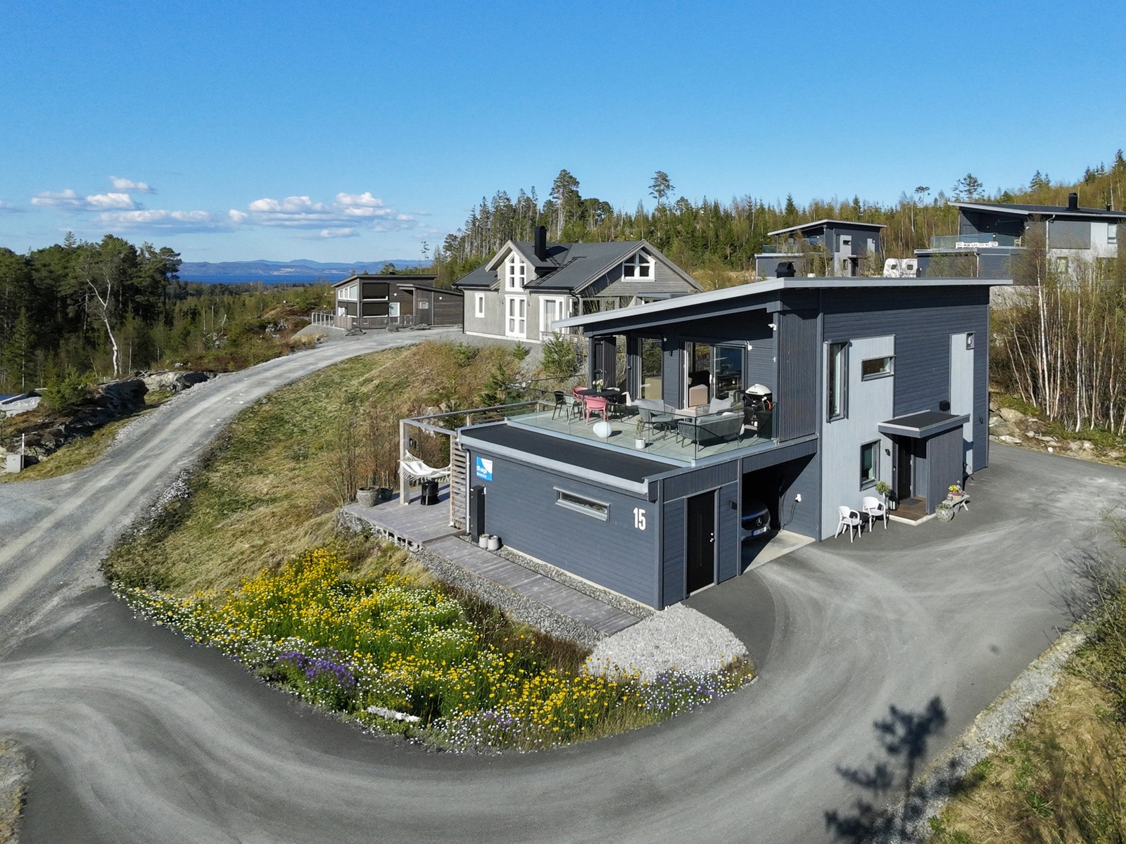 Moderne og innholdsrik hytte med bl. a. 2 bad, 5 soverom og carport. Blomstereng er digitalt redigert, det vil bli sådd denne sommeren. Galleribilde