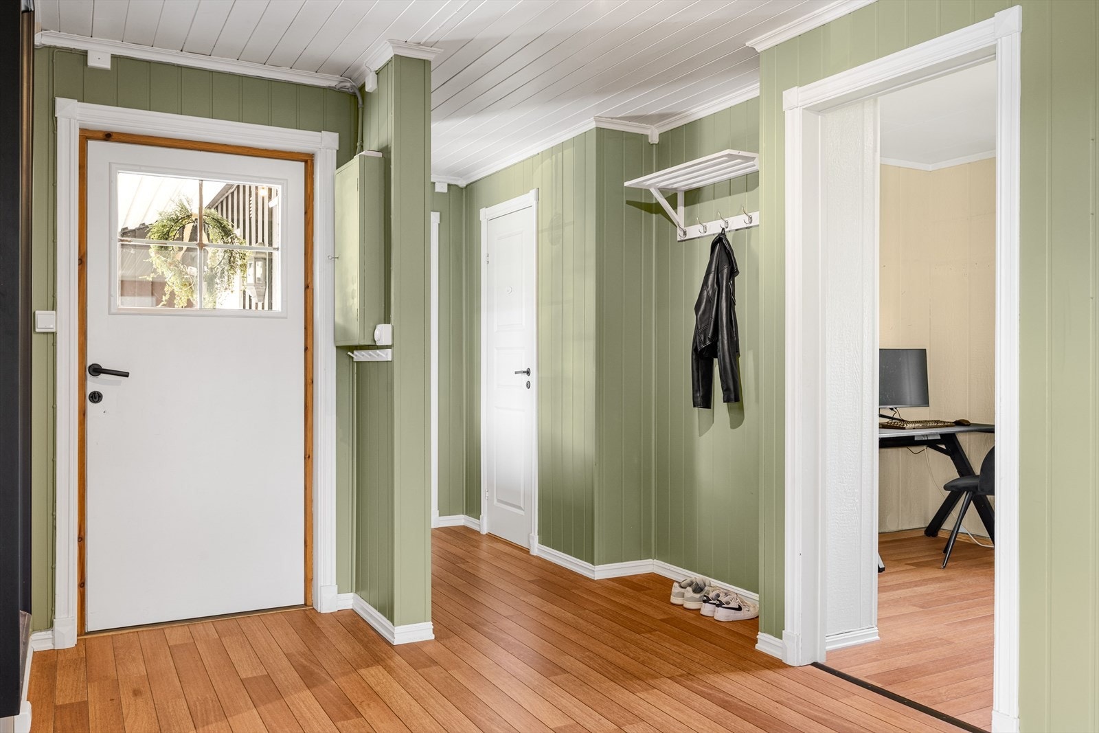 Du møtes av gang med grønnmalte vegger, lys himling og laminatgulv. Galleribilde