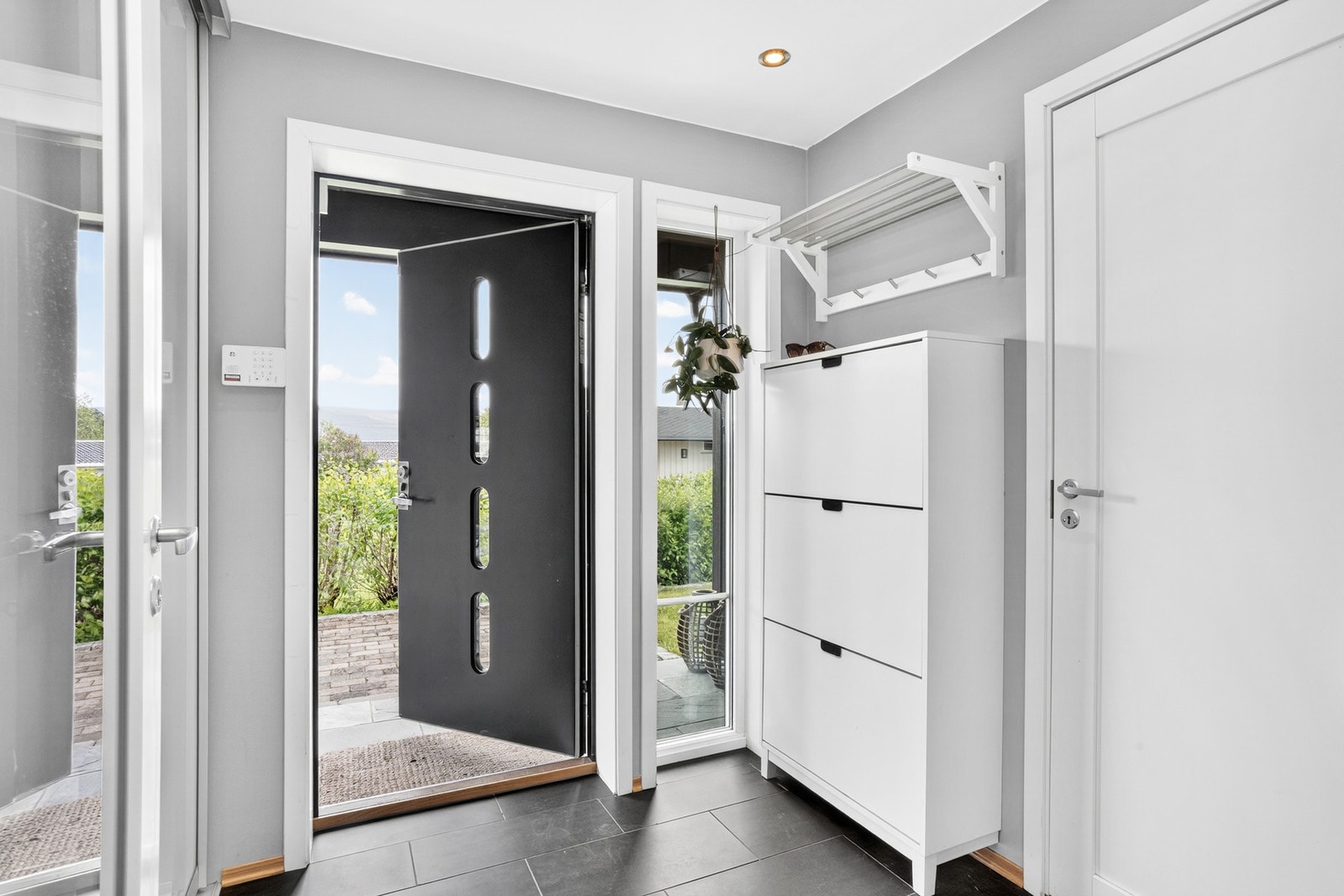 Entréen har gode oppbevaringsmuligheter med skyvedørsgarderobe og skoskap Galleribilde
