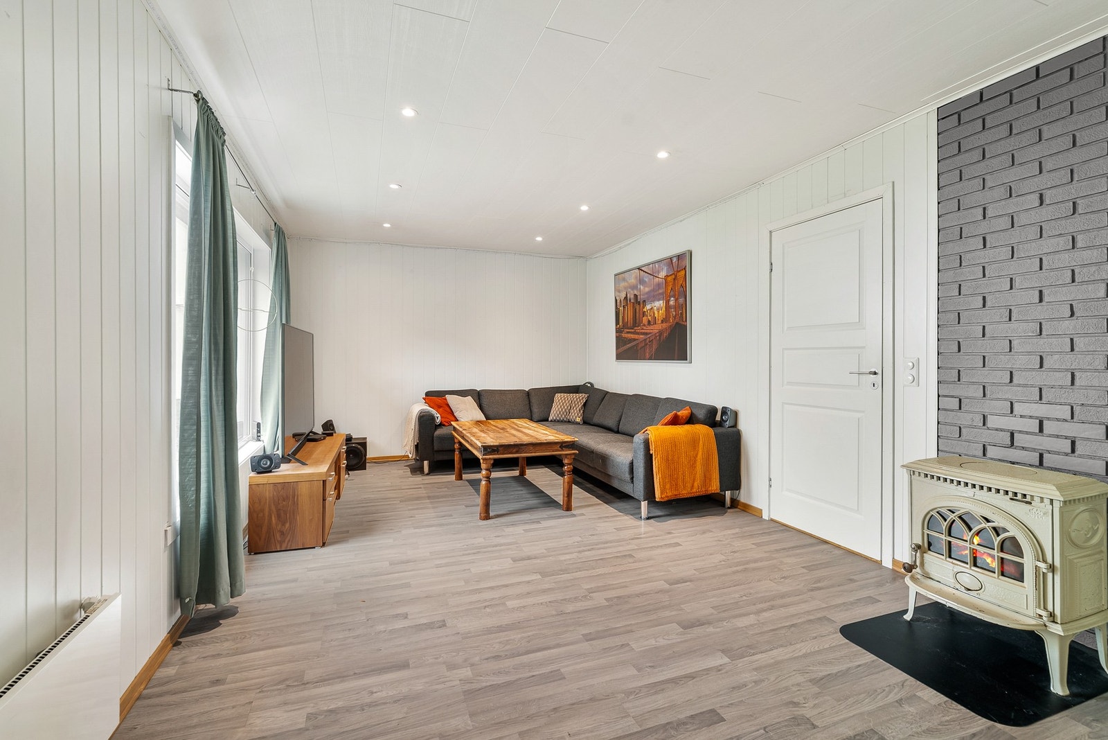 Stuen har plass til en romslig sofagruppe. Vedovnen gir ekstra varme. Galleribilde