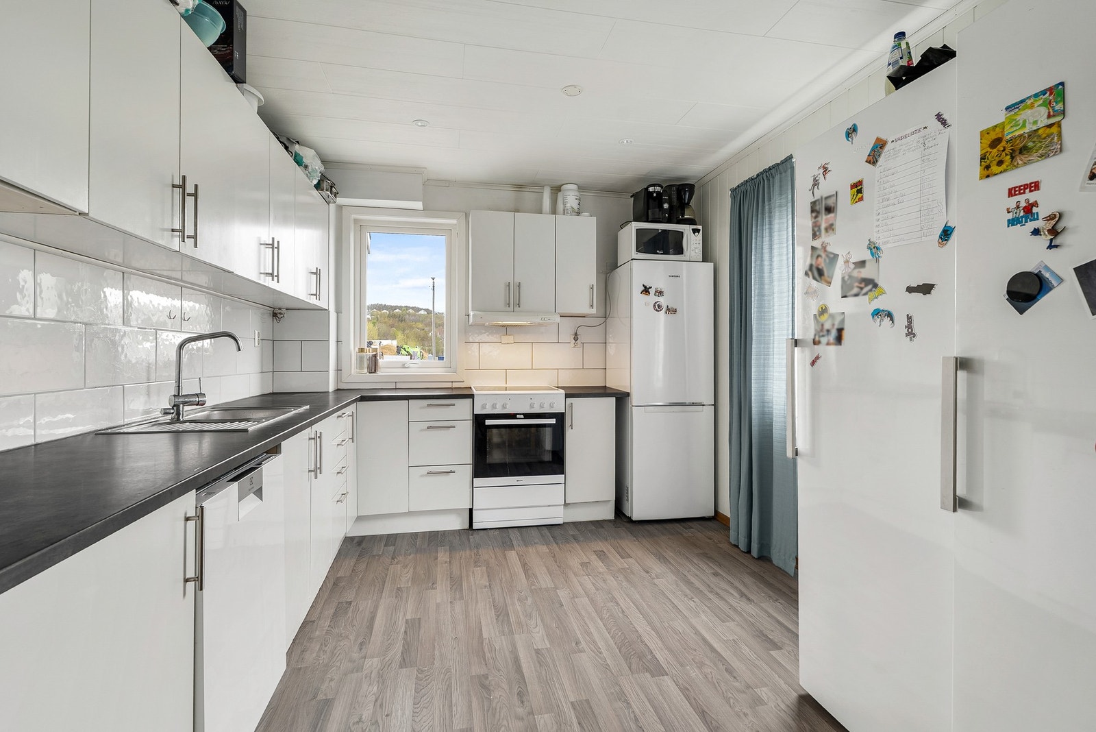 Kjøkkeninnredning med glatte fronter og benkeplate av laminat. Galleribilde