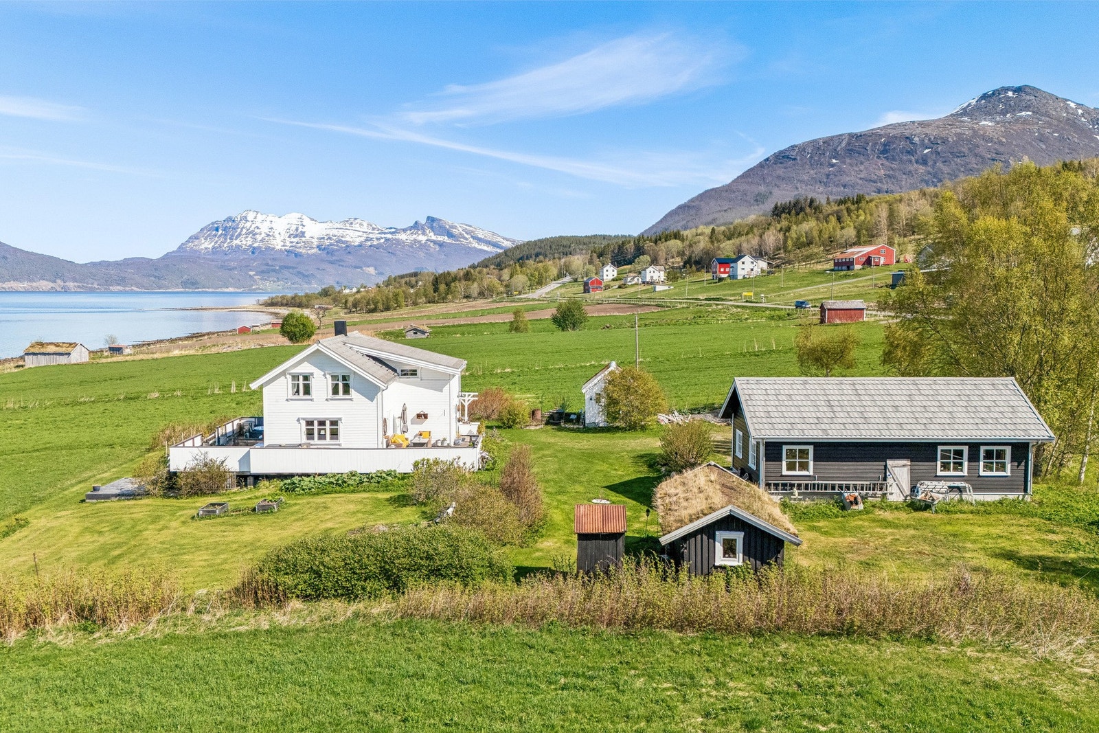 Landlig tun med garasje, lysthus og lekestue/eldre stabbur. Galleribilde