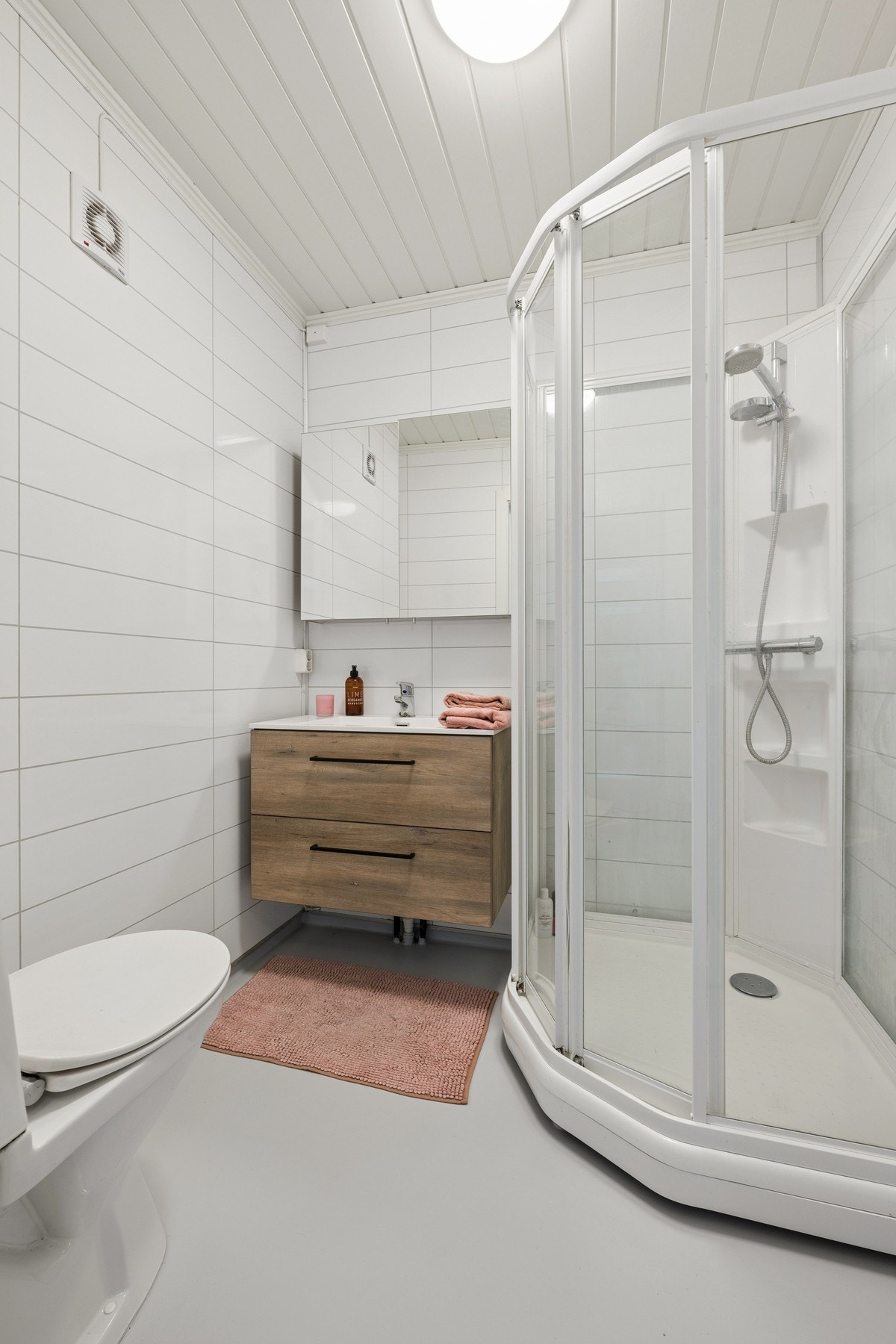 Badet holder en lys og tidløs standard. Rommet er innredet med servant, toalett og dusjkabinett. Galleribilde