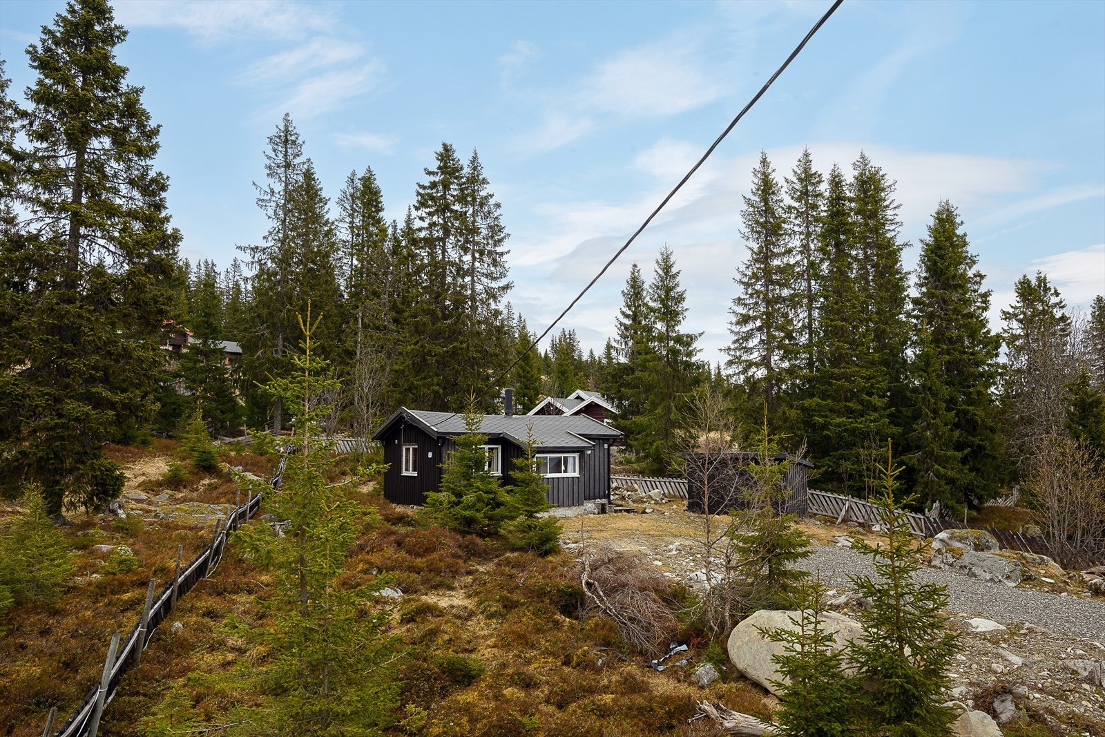 Hytta ligger forholdsvis usjenert til, omkranset av fjellskog. Galleribilde