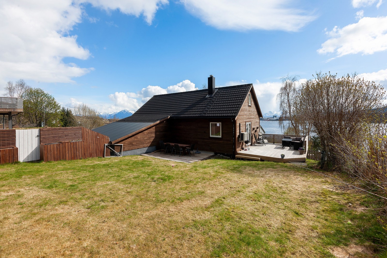 Tomten er pent opparbeidet med plen og beplantning. Galleribilde