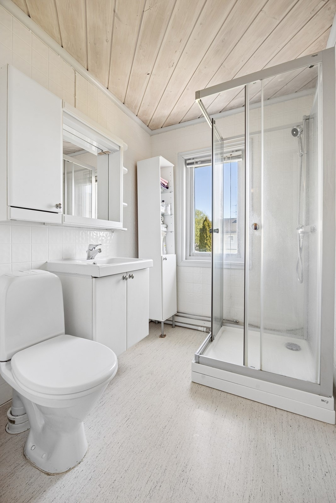Videre er badet innredet med dusjkabinett og gulvstående toalett. Galleribilde