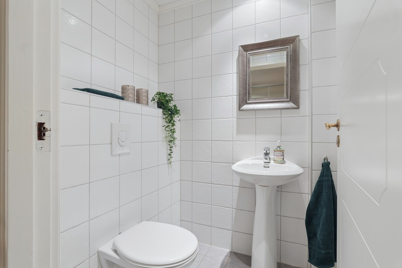 Like ved hall finner man gjestetoalettet som har flislagt gulv og flislagte vegger - og er utstyrt med vegghengt toalett og servant Galleribilde