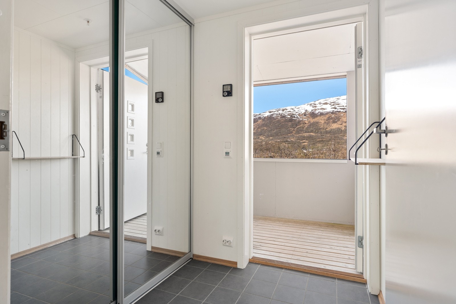 Velkommen inn til flislagt entré med skyvedør inn til stor walk-in garderobe/bod