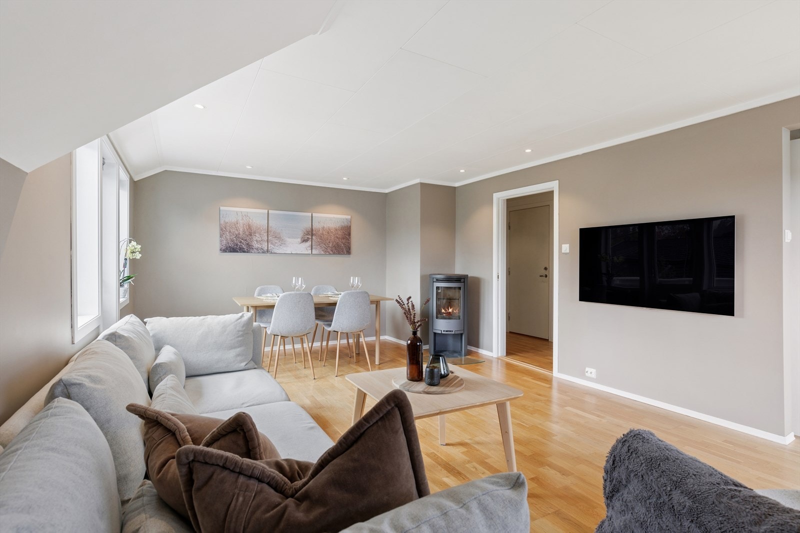 Romslig stue med god plass til sofa og spisebord Galleribilde