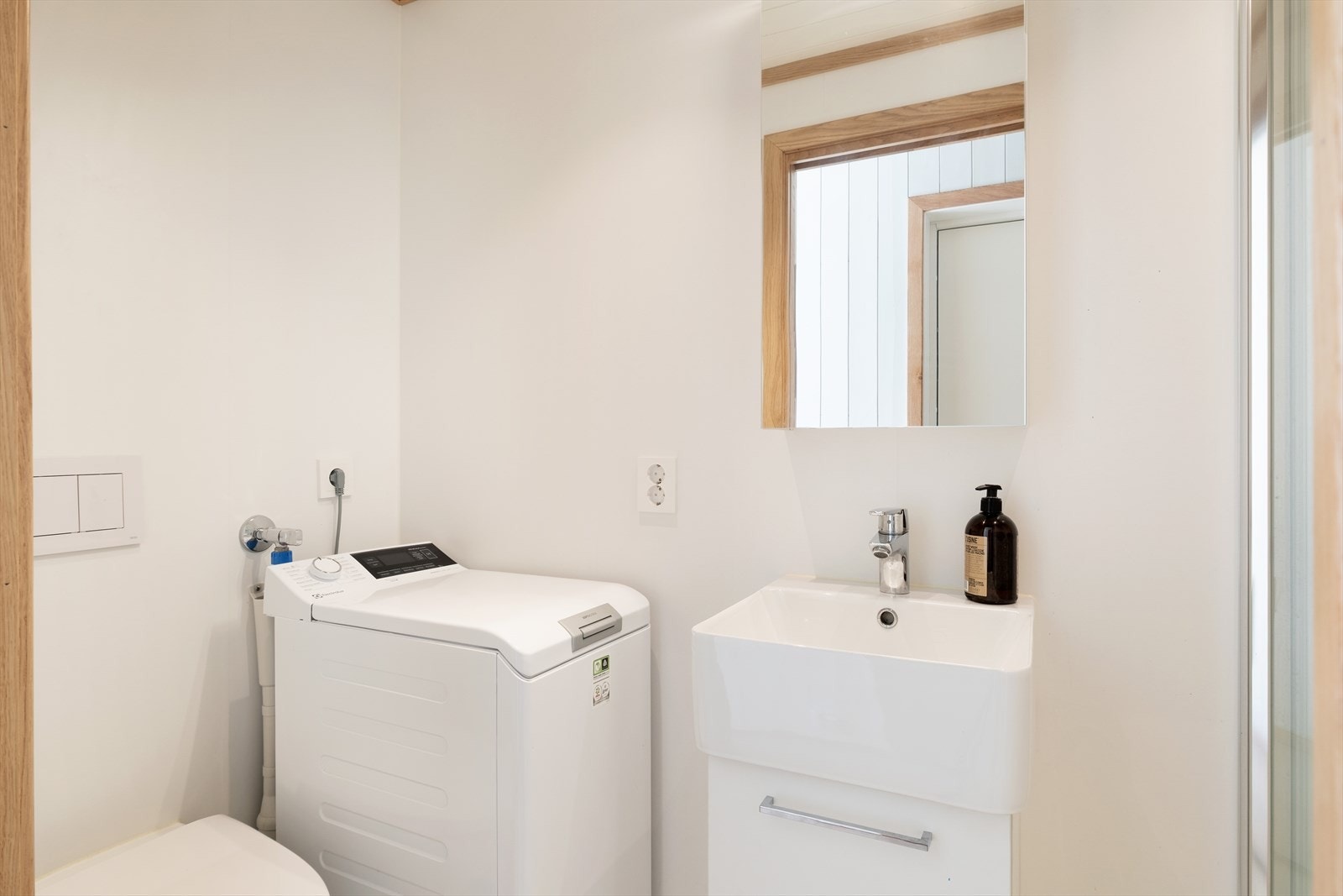 Badet har baderomsplater på veggene, panel i taket og vinylbelegg med varmekabler i gulvet. Rommet er utstyrt med servant, toalett, dusjhjørne med glassvegger, opplegg for vaskemaskin og elektrisk styrt vifte. Galleribilde
