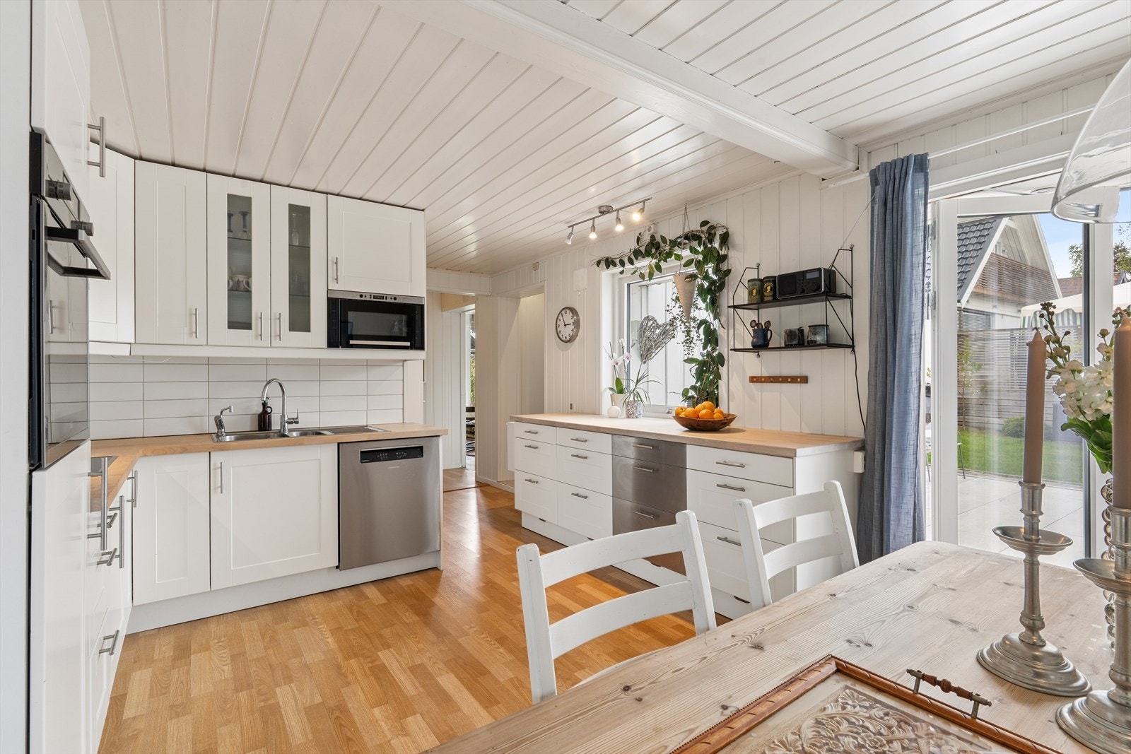 Innbydende kjøkkenløsning med spiseplass og direkte adkomst til hage/terrasse Galleribilde
