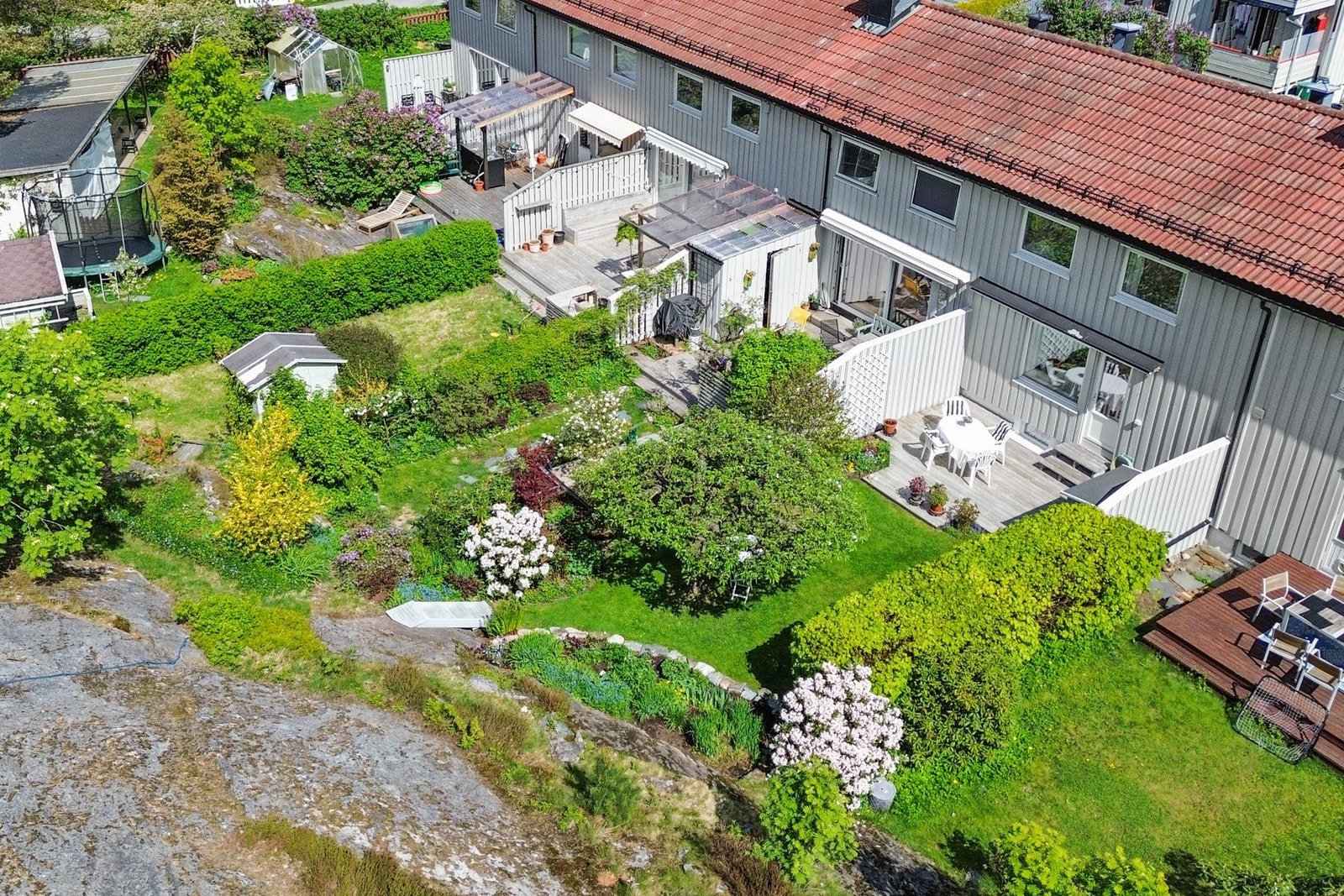 Tomten er flat og skrånende og flott opparbeidet med gressplen, beplantning og god plass til hagemøblement. Galleribilde