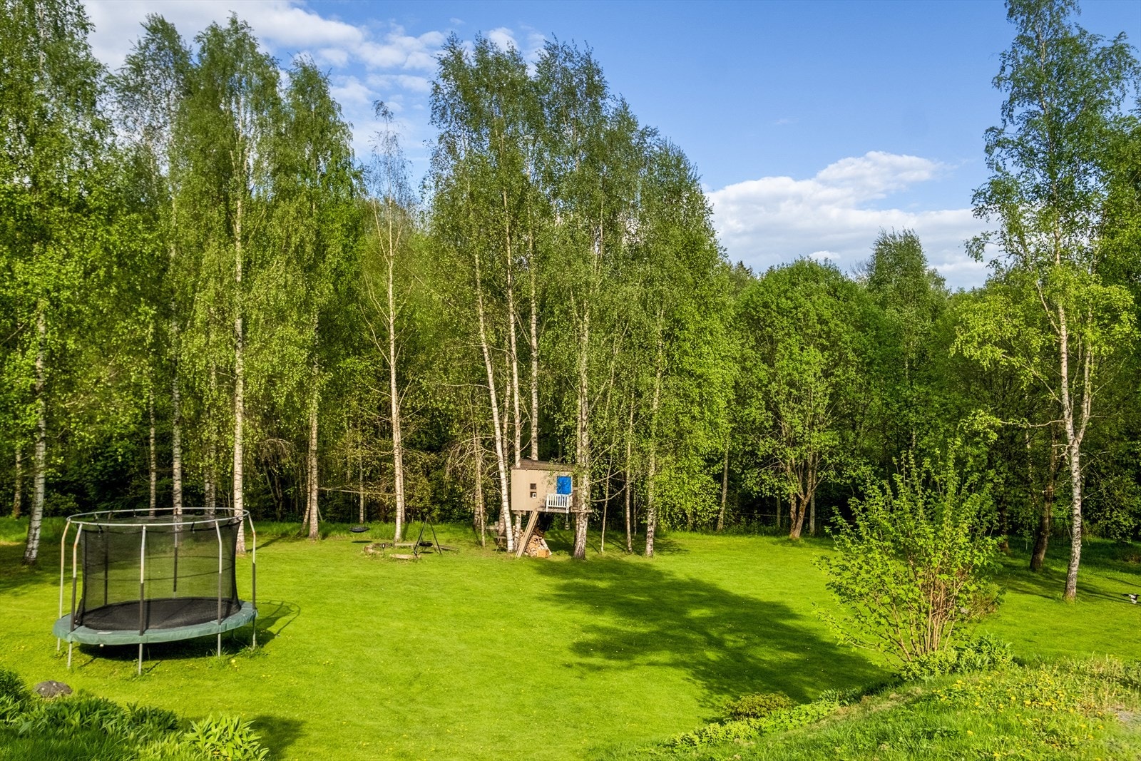 Store og grønne fellesområder med trehytte, trampoline og gode rekreasjonsmuligheter for både små og store Galleribilde