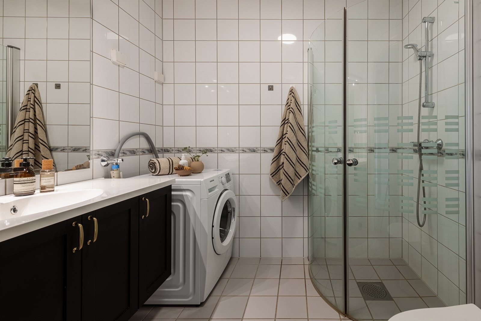 Badet er innredet med romslig dusjhjørne, bred servantløsning med underskap og speil, samt klosett. Galleribilde