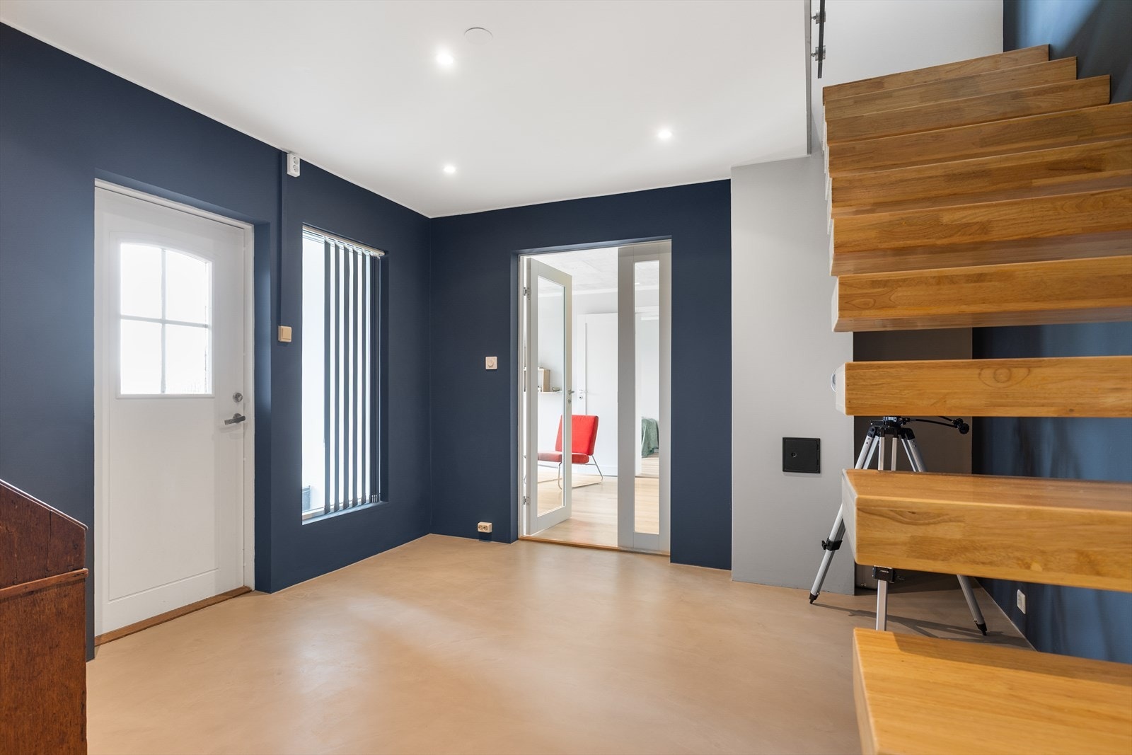 Hallen i underetasjen har utgang til hagen via en malt ytterdør og videre adkomst til tilbygget del med kjellerstue og to soverom. Galleribilde