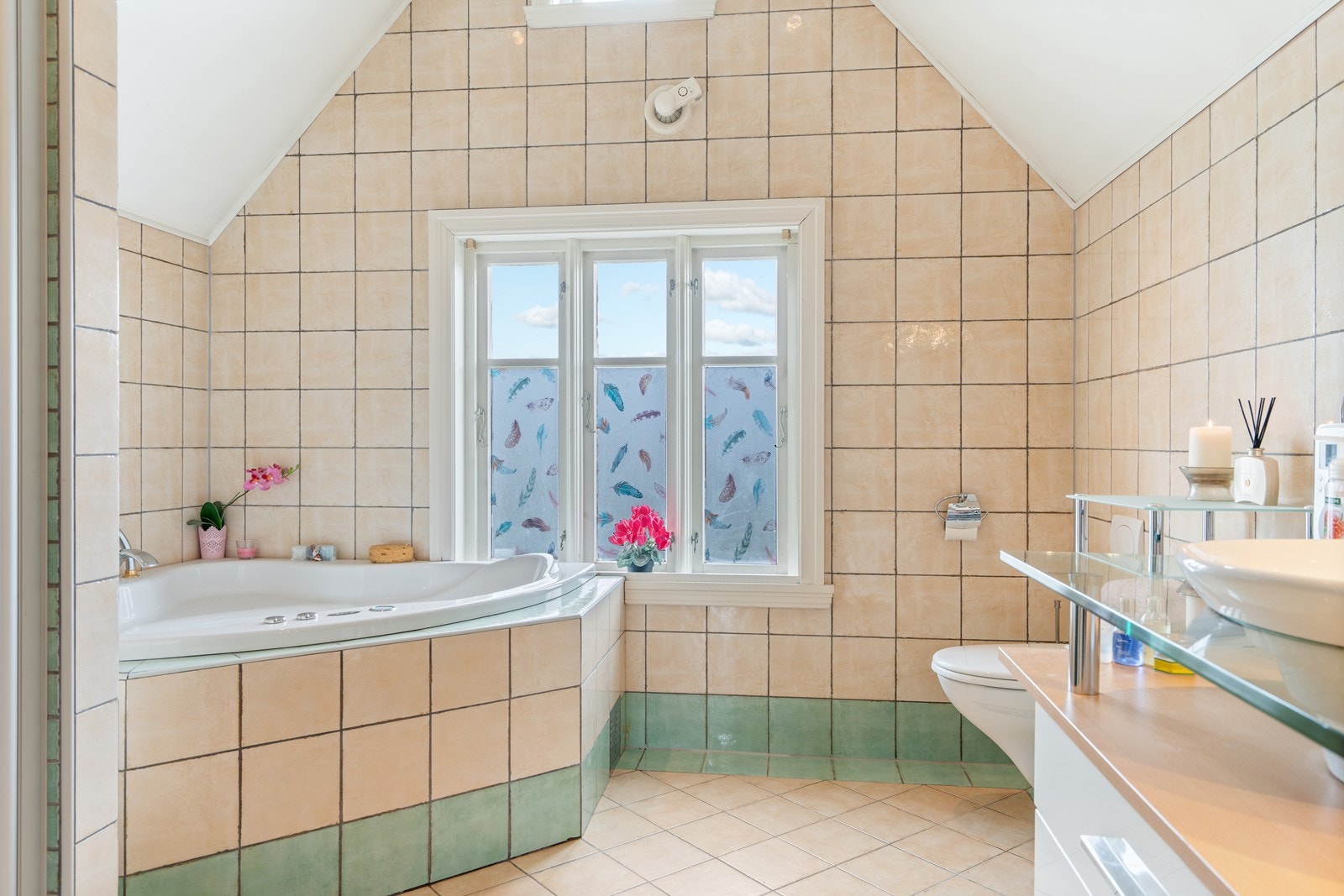 Badet inneholder badekar, dusjsnisje, vegghengt toalett og innredning med servant Galleribilde