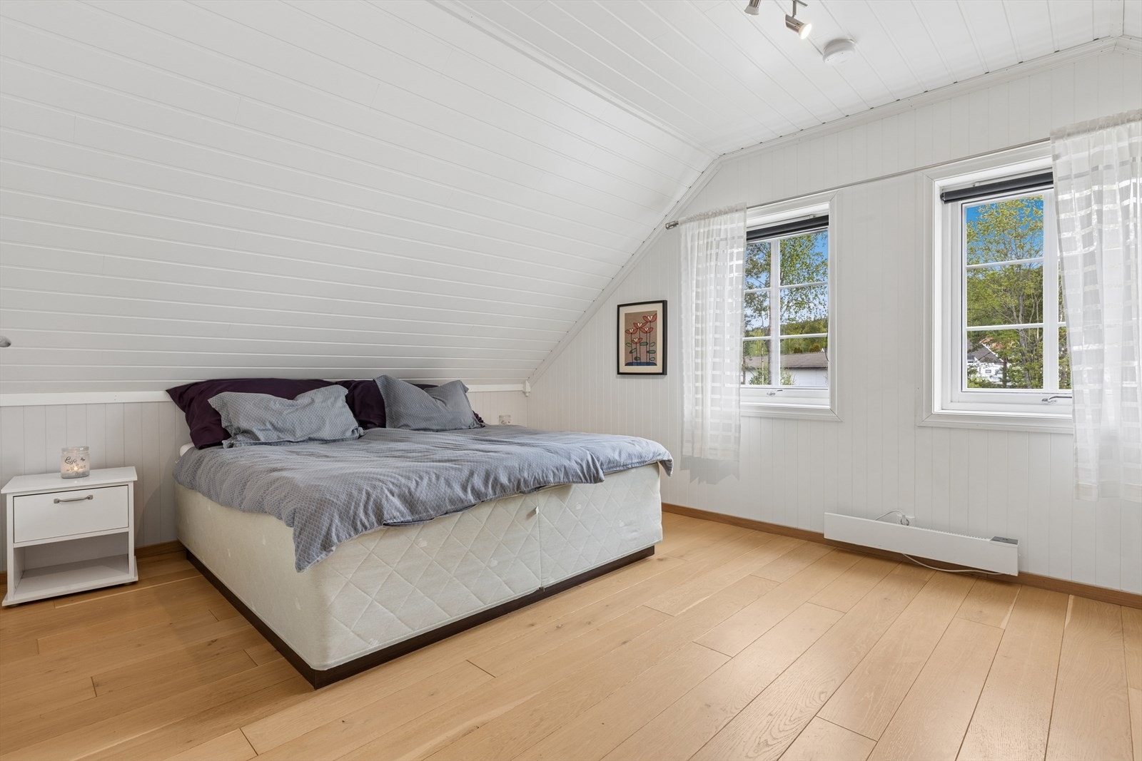 Lyst soverom med panel i taket og god plass til dobbeltseng. Galleribilde